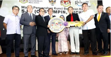  ??  ?? Abang Johari (fourth left) witnesses Yek (fourth right) handing over a mock key to Abang Mat Ali (third left) while (from right) Chan, Dr Sim, Lee, Juma’ani, Awang Tengah and Dr Annuar look on.