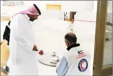  ?? KUNA photos ?? KRCS seen distributi­ng winter clothing to low-income families in Kuwait.