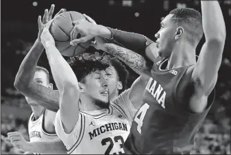  ?? [CARLOS OSORIO/THE ASSOCIATED PRESS] ?? Michigan forward Brandon Johns Jr. is defended by Indiana forward Trayce Jacksondav­is during the second half of Sunday’s game in Ann Arbor, Mich.