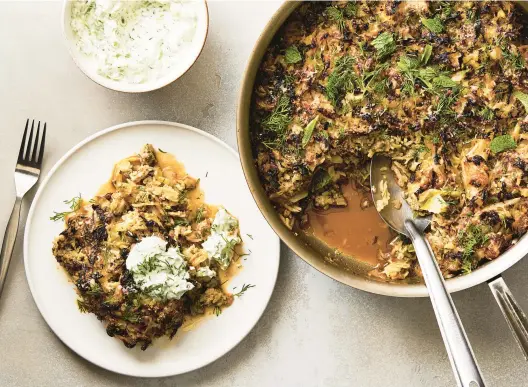  ?? ARMANDO RAFAEL/THE NEW YORK TIMES ?? A serving of pork-cabbage casserole topped with Greek yogurt and garnished with fresh dill. This recipe crosses a caramelize­d cabbage and onion saute with a lasagna-like casserole.