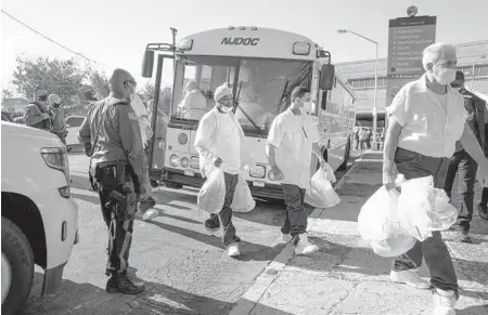  ?? JONAH MARKOWITZ/THE NEW YORK TIMES ?? Due to COVID-19 protocols, inmates are granted early release Nov. 4 in Newark, New Jersey. Officials are finding it hard to keep jails and prisons open as the coronaviru­s ravages prisoners and staffers. Almost 100,000 correction­al officers have tested positive for the virus.