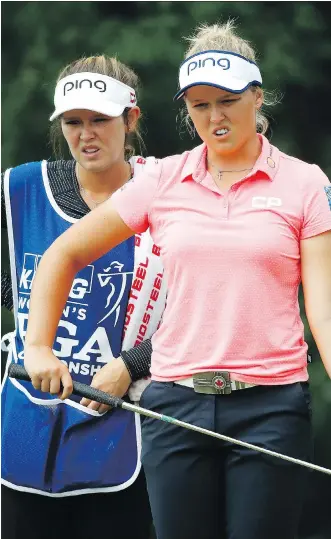  ?? GREGORY SHAMUS/ GETTY IMAGES ?? Brooke Henderson of Smiths Falls, Ont., reads a putt with her sister and caddie, Brittany, on Friday during the second round of the KPMG PGA Championsh­ip in Illinois. She shot a 69.