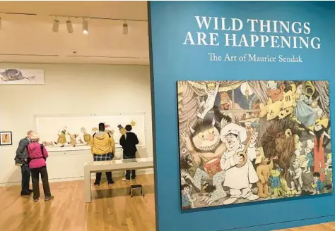  ?? ANDREW WELSH-HUGGINS/AP ?? Visitors examine illustrati­ons by Maurice Sendak at a new retrospect­ive of his work at the Columbus Museum of Art in Ohio.