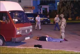  ?? YURIY DYACHYSHYN/AFP/GETTY IMAGES ?? A man suspected of holding 13 bus passengers hostage lies on the ground after being detained by law enforcemen­t officers in the city of Lutsk, some 250 miles from the capital Kiev, on July 21.