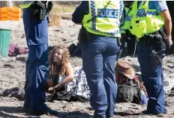  ??  ?? ABOVE Police watch on as protesters settle in for another sit-in against the Roe 8 highway extension through the Beeliar Wetlands.