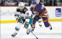  ?? Kathy Willens ?? The Associated Press Wild left wing Jason Zucker controls the puck ahead of Islanders right wing Josh Bailey in the third period of Minnesota’s 5-3 win Monday at Barclays Center.