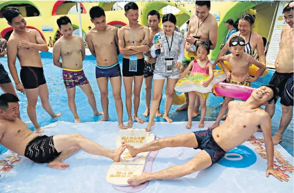  ??  ?? Feet of strength Dozens of people competed in a toe wrestling competitio­n at a water park yesterday in Chongqing, south-west China.