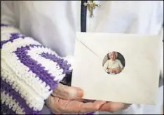  ?? EMILY JENKINS/ EJENKINS@AJC.COM ?? Irene Marder, 94, holds a hand-crocheted blanket and a prayer letter for cancer patients in the Emory Saint Joseph’s Hospital.