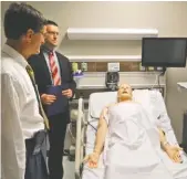  ??  ?? Lee University President Dr. Paul Conn, left, and Brian Conn, director of public relations for the university, observe a patient simulator at the new building.