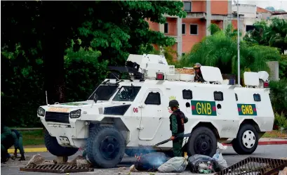  ?? AFP ?? Members of the National Guard clear a barricade set by anti-government activists in the city of Valencia. —