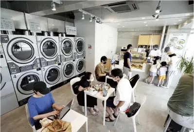  ?? The Yomiuri Shimbun ?? Customers relax at Baluco Laundry Place Yoyogi-Uehara in Shibuya Ward, Tokyo, on Aug. 20.