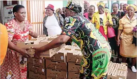  ??  ?? National Women’s League vice treasurer Cde Magarine Khumalo (left) hands over chicks to women in Gwanda yesterday