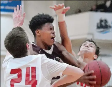  ?? TIM MARTIN/THE DAY ?? Dev Ostrowski, center, of East Lyme, attempts to get through NFA defenders Brendan Maher (24) and Alec Gomes, right, during the second half of Tuesday’s game in Norwich. East Lyme won the game 4838 to clinch the ECC Division I championsh­ip.