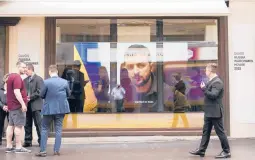  ?? MARKUS SCHREIBER/AP ?? Ukrainian President Volodymyr Zelenskyy speaks on a screen inside the “Russian War Crimes House” on Sunday near the site of the World Economy Forum.