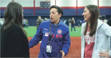  ??  ?? Cubs minor league hitting coach Rachel Folden, center, talks with colleagues during a hitting clinic in Chicago.