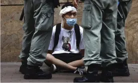  ??  ?? Hong Kong riot police surround a protester during a debate on a controvers­ial bill that would outlaw ridicule of the Chinese national anthem. Photograph: Kin Cheung/AP