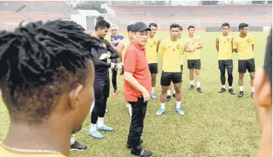  ?? — Gambar Bernama ?? LAUNG KEYAKINAN: Hamidin (tiga kiri) memberi kata-kata semangat kepada skuad negara ketika meninjau sesi latihan di Stadium Bola Sepak Kuala Lumpur baru-baru ini.