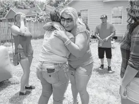  ?? Annie Mulligan ?? Alana Mock hugs a friend at a barbecue benefit on July 22 to raise funds for her daughter Layla Ramos’ funeral. Layla was shot two days earlier in Atascocita.