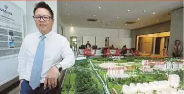  ??  ?? Sunsuria Bhd chief operating officer Simon Kwan with the scale model of Tangerine Suites at Sunsuria City.