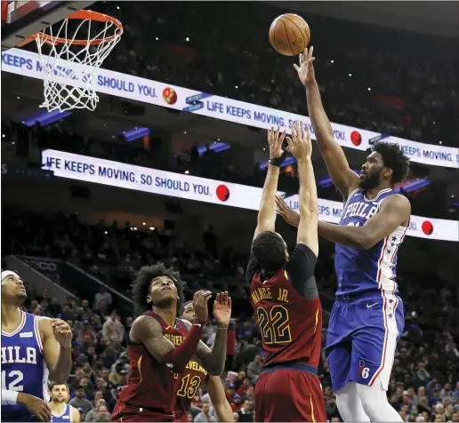  ?? MATT SLOCUM — THE ASSOCIATED PRESS ?? The 76ers’ Joel Embiid, right, goes up for a shot against the Cavaliers’ Larry Nance Jr. during the first half of a game Tuesday night between the teams at Wells Fargo Center.