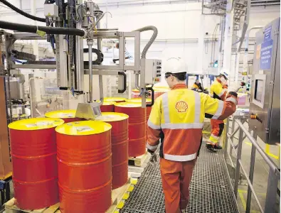  ?? ANDREY RUDAKOV / BLOOMBERG FILES ?? A machine fills barrels with lubricant oil at the Royal Dutch Shell Plc lubricants blending plant in Torzhok, Russia.