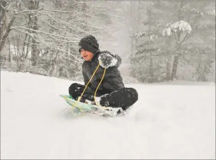  ?? Ben Lambert / Hearst Connecticu­t Media ?? Richard Klug, 13, of Torrington, slides down the hill at Major Besse Park on Wednesday afternoon, as a nor’easter brought snow to the area.