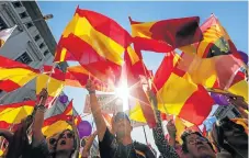  ?? /Reuters ?? Calls for unity: People wave Spanish flags during a pro-union demonstrat­ion in Barcelona, Spain on Sunday.