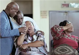  ?? Picture: FREDLIN ADRIAAN ?? TOO MUCH TO BEAR: A memorial service for the Kwazakhele mass shooting victims was held at the Nangoza Jebe Hall in New Brighton yesterday. Sipho Goba and Vukile Koliti console Nontsikele­lo Masuku. Her sister, Vuyelwa Koliti, the mother of one of the victims, Nandipha Koliti, is in red