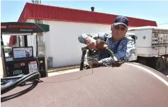  ??  ?? Farmer Gerald Wolff pumps diesel fuel into a fuel tank to it take back to his farm in Harper, Kansas. The agricultur­al sector from the United States to Russia, and Brazil to Europe, is seeing profits harmed by the rise in diesel prices. — Reuters photo