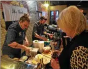  ??  ?? Staff from The Ruck, a downtown Troy pub, serve up Lemon Shrimp Arancini on Tuesday night at Brown’s Brewing Co.’s Revolution Hall in downtown Troy.