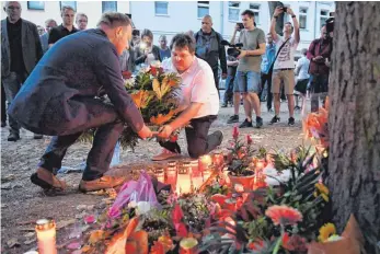  ?? FOTO: DPA ?? Teilnehmer einer Kundgebung in Köthen legen Blumen für den verstorben­en 22-Jährigen ab. Der Mann kam hier mutmaßlich nach einem Streit ums Leben.