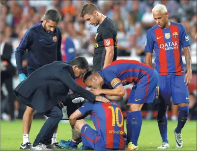  ?? ALBERT GEA / REUTERS ?? Lionel Messi sits on the pitch injured, next to Andres Iniesta, Neymar and medical staff member Ricard Pruna at Camp Nou in Barcelona.