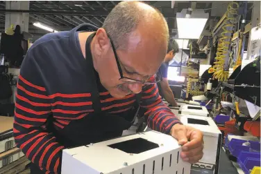  ?? Michael Hill / Associated Press ?? Iraqi refugee Majid Al Lessa works at a lighting fixture plant in Buffalo, N.Y. He and thousands of refugees have settled there even as others have left for places with less snow and more jobs.