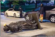  ?? (AP/Wisconsin State Journal/Emily Hamer) ?? A statue representi­ng Wisconsin’s motto, “Forward,” lies in the street Tuesday night on Capitol Square in Madison.