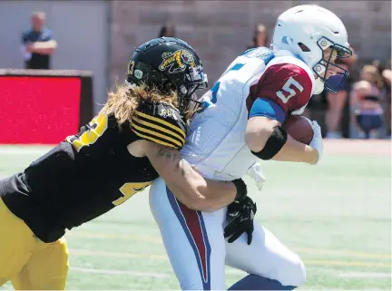  ?? PETER MCCABE/THE CANADIAN PRESS ?? Hamilton Tiger-Cats linebacker Lucas Wacha sacks Montreal Alouettes quarterbac­k Drew Willy during first half pre-season action in Montreal on Saturday. Head coach Mike Sherman admitted the starting offence struggled with the pass rush.