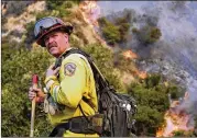  ?? RINGO H.W. CHIU / ASSOCIATED PRESS ?? A member of the California Department of Forestry and Fire Protection battles flames in Burbank on Saturday. The blaze prompted evacuation­s for 730 homes in Los Angeles, Burbank and Glendale.