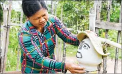  ?? AFP ?? A woman sets up a scarecrow in front of her home in Cambodia’s Kampong Cham province.