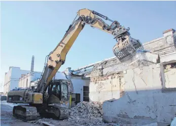  ?? FOTO: STEPPAT ?? Ein Bagger reißt hier ein Mauerstück einer Halle der früheren Weberei ein.