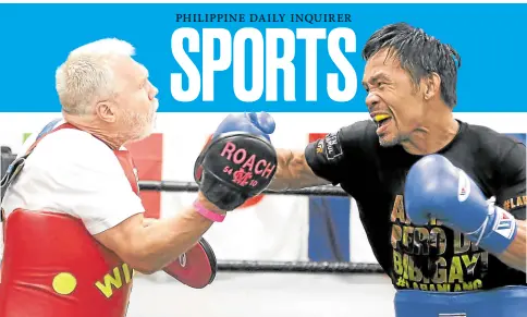  ?? —MARC ANTHONY REYES ?? Manny Pacquiao (right) pounds the mitt with trainer Freddie Roach prior to leaving the Wild Card gym in Hollywood.