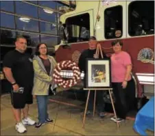  ?? LORETTA RODGERS — DIGITAL FIRST MEDIA ?? Julie Amber-Messick, second from right, mother of fallen junior firefighte­r Christophe­r Kangas, poses in front of a picture of her son with Brookhaven Fire Chief Rob Montella, Fire Co. President Jon Grant and Patti Montella, who organized Friday’s...