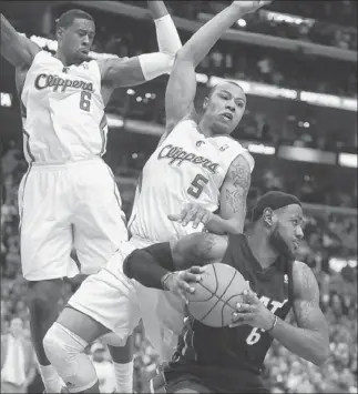  ?? Wally Skalij
Los Angeles Times ?? THE CLIPPERS are 22nd in the league in points allowed, but don’t tell that to Miami’s Lebron James, who is harassed by Deandre Jordan, left, and Caron Butler during Wednesday’s game.
