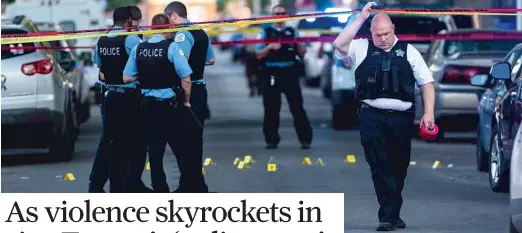  ?? TYLER LARIVIERE/SUN-TIMES ?? Chicago police officers investigat­e the scene of a deadly shooting where a 7-year-old girl and a man were fatally shot on July 5.