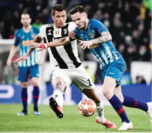  ?? Photo: AFP ?? Atletico Madrid’s Spanish midfielder Saul Niguez (R) outruns Juventus’ Croatian forward Mario Mandzukic during the UEFA Champions League round of 16 second-leg match at the Juventus stadium in Turin yesterday