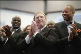  ?? JOHN LOCHER — THE ASSOCIATED PRESS FILE ?? Oakland Raiders owner Mark Davis, center, claps as he attends a bill signing ceremony with Nevada Gov. Brian Sandoval in Las Vegas. Sandoval signed a bill into law that clears the way for a Las Vegas stadium that could be home to UNLV football and the...