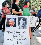  ?? ?? A demonstrat­or stands with a sign showing the faces of Israeli PM Benjamin Netanyahu and Nazi Germany’s leader Adolf Hitler. (AFP)