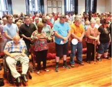  ?? CURTIS COMPTON/ATLANTA JOURNAL-CONSTITUTI­ON ?? Locals bow for opening prayer in Covington, Ga. Most opposed a mosque.