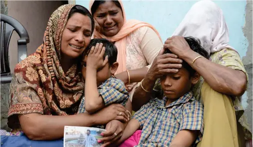  ??  ?? Indian resident Seema, left, her sons Karan, second right, and Arjun, second left, and her mother in-law Jeeto react on Tuesday following confirmati­on by External Affairs Minister Sushma Swaraj that her husband Sonu had been killed in Iraq, in the...