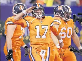  ??  ?? The Broncos’ Brock Osweiler, centre, salutes the crowd after a touchdown against the Colts at Lucas Oil Stadium.
