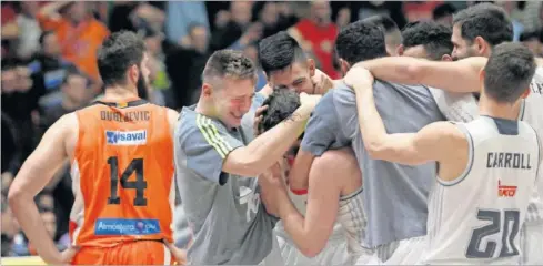  ??  ?? ALEGRÍA DESATADA. Los jugadores del Madrid, con Doncic a la izquierda (ayer cumplió 17 años), abrazan al héroe del día, a Sergio Llull.