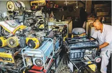  ?? AP ?? ■
A worker repairs generators at his shop in Basra. Some areas face daily outages of up to 14 hours in peak summer.